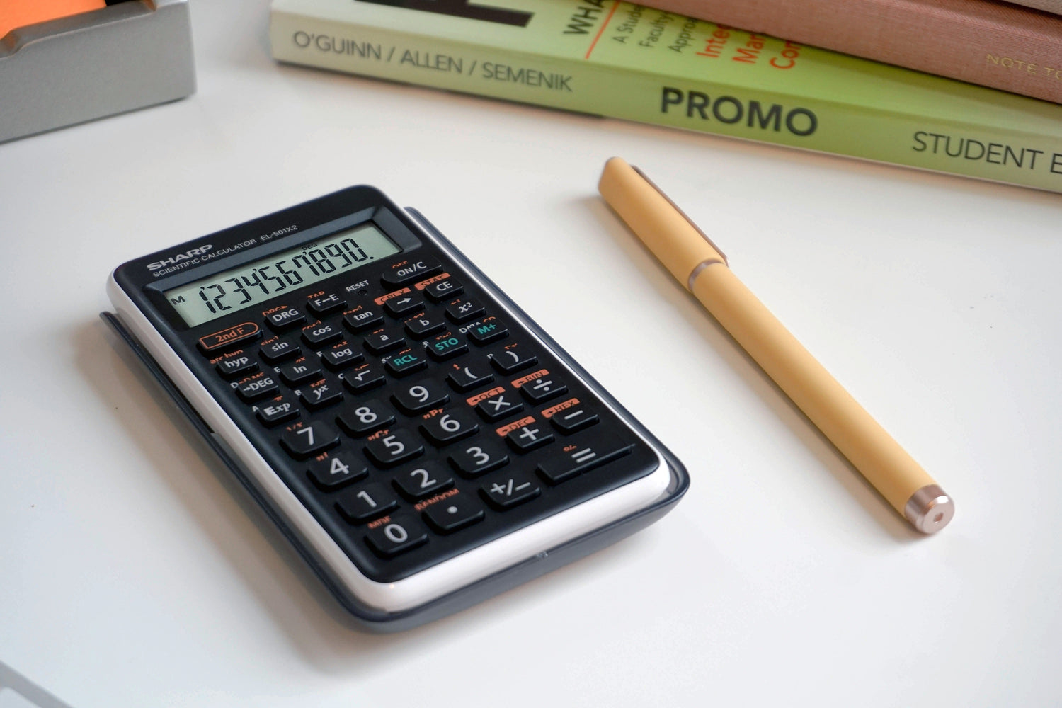 black scientific calculator with math textbooks in the background